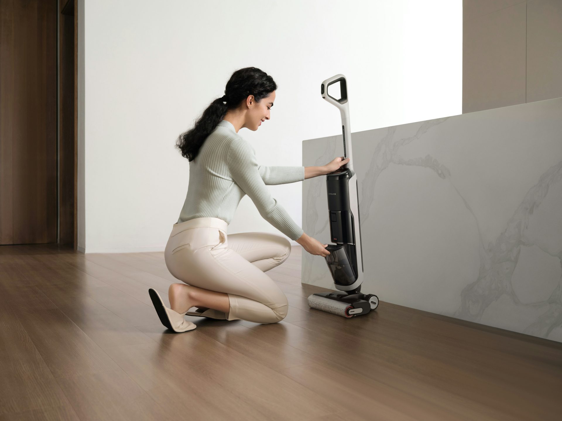 Woman cleaning floor with a wet dry vacuum cleaner.